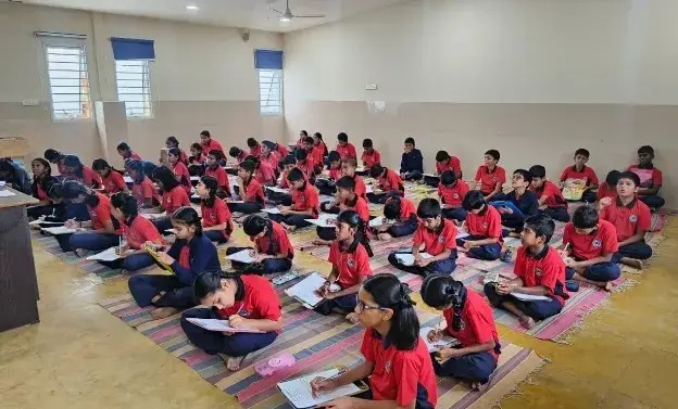 Friendly preschool teacher reading a picture book to attentive young children in a cozy corner